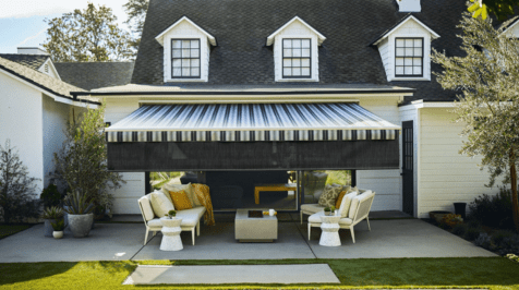A cozy outdoor seating area with striped awning and cushioned chairs.