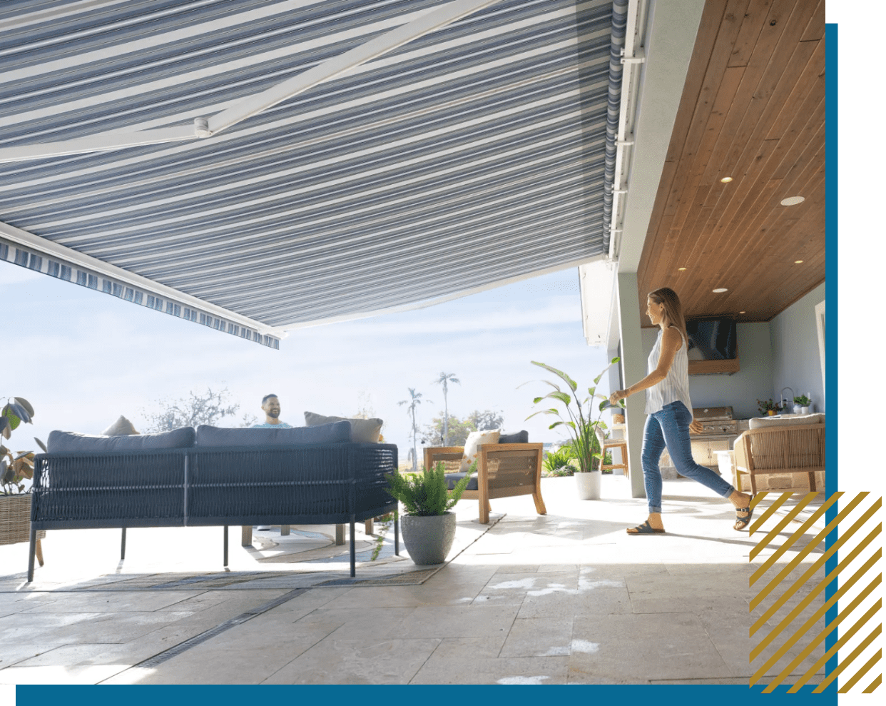 A person opening a large retractable awning on a sunny patio.